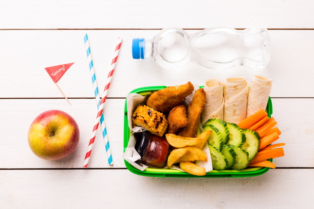 Picnic lunch box with chicken, fries, tortilla and vegetables