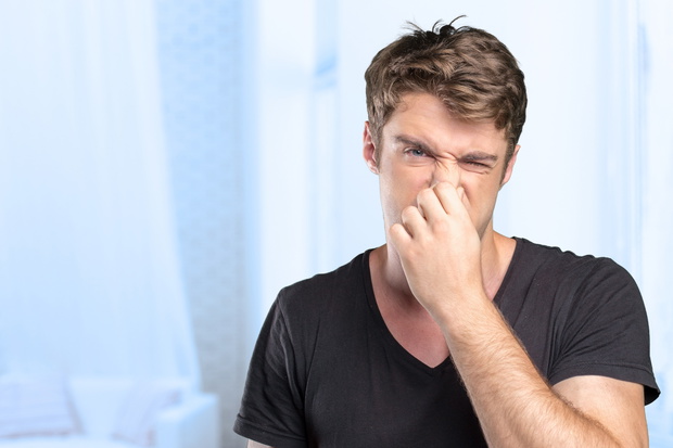 Man holding his nose against a bad smell