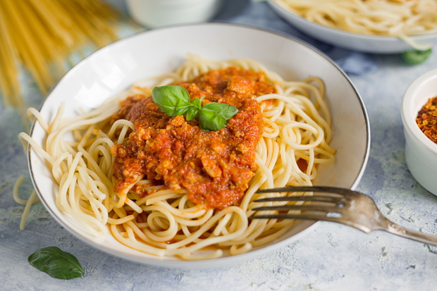 Spaghetti with basil garnish in meat sauce