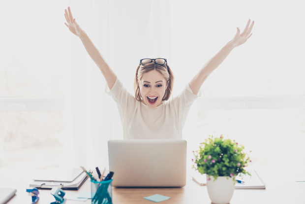 Happy excited successful businesswoman triumphing with laptop