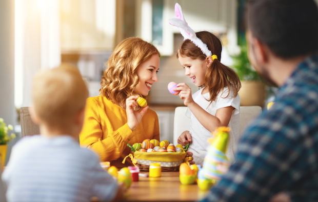 Happy easter! family mother, father and children paint eggs for holiday