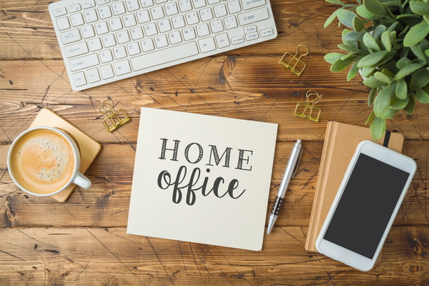 Home office and working from home concept. Table workplace with keyboard computer, notepad and coffee cup. Top view from above