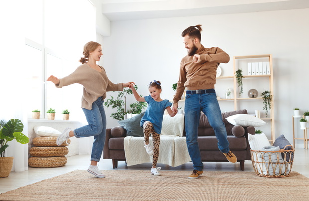 happy family mother father and child daughter dancing at home