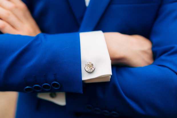 Crossed man's hands on his chest in a blue jacket. Cuff links fr
