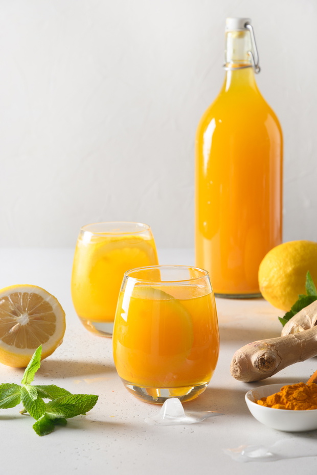 Jamu Indonesian drink with natural ingredients turmeric, ginger, lemon on white background. Close up.