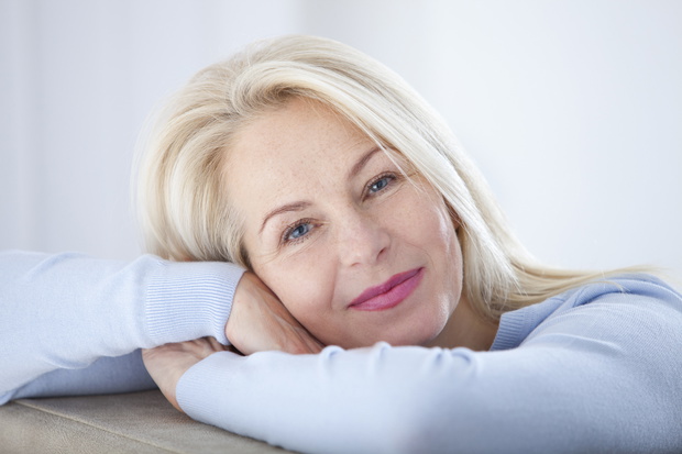 Active beautiful middle-aged woman smiling friendly and looking in camera. Woman's face closeup. Realistic images without retouching with their own imperfections. Selective focus.