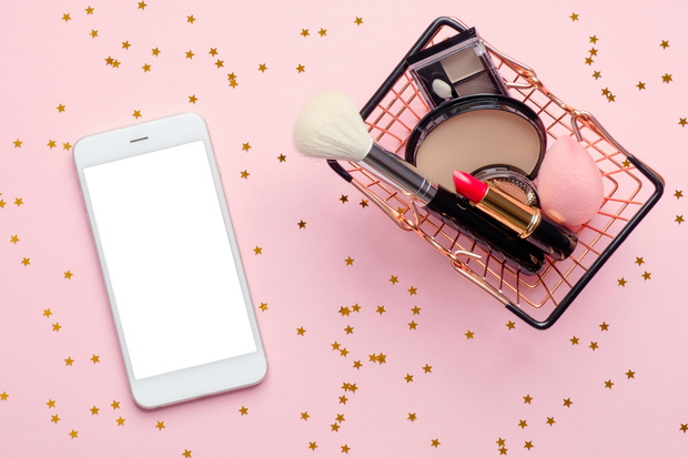 Buying beauty products online concept. Shopping basket with make