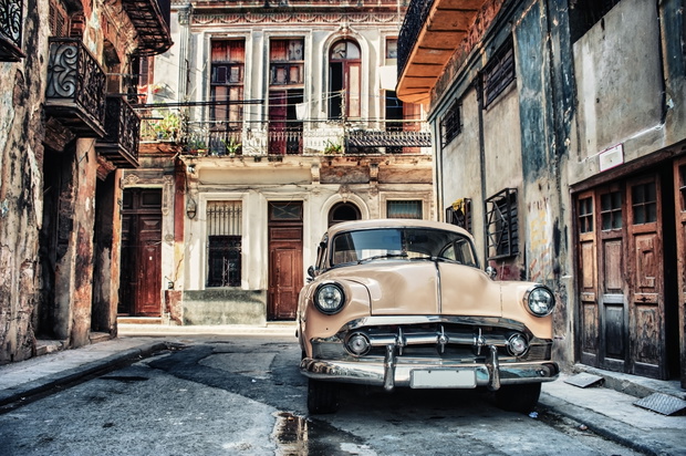 Old classic car in a street of havana with buildings in backgrou