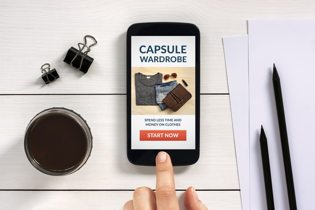 Capsule wardrobe concept on smart phone screen with office objec