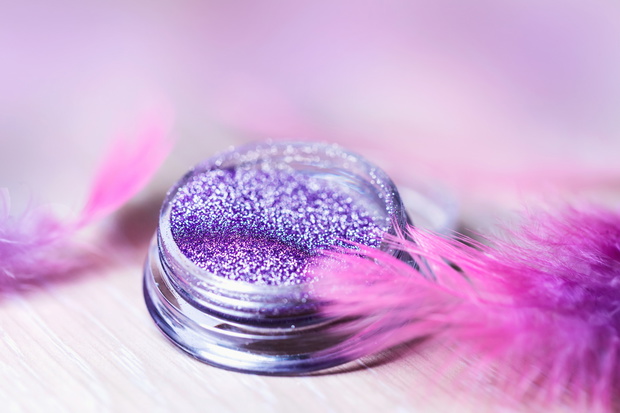 Beautiful glitter of actual purple color in a nail salon to create a nail design. Materials for manicure and makeup. Conceptual trend, color of the year 2022 Very Peri.