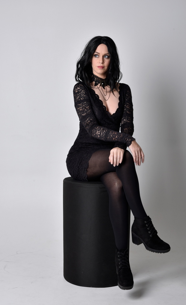 Portrait of a goth girl with dark hair wearing black lace dress
