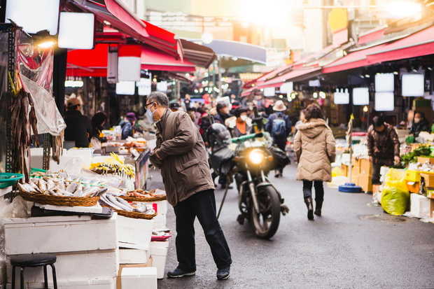 Market in Asia. Buyers with medical masks on their faces choose