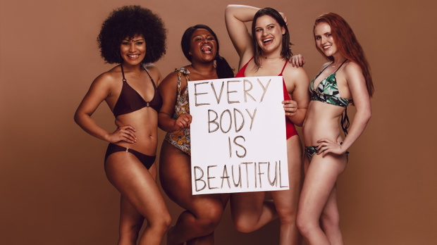 Different size females holding a every body is beautiful placard
