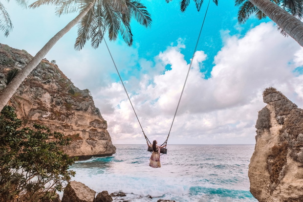 Beautiful girl on swing coconut palms on beach at Daimond  beach