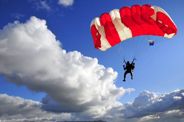 Red,Parachute,Landing,On,Stormy,Sky.