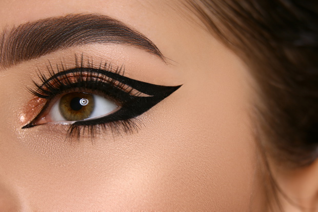 close-up of woman eye with sexy eyeliner and golden shadow