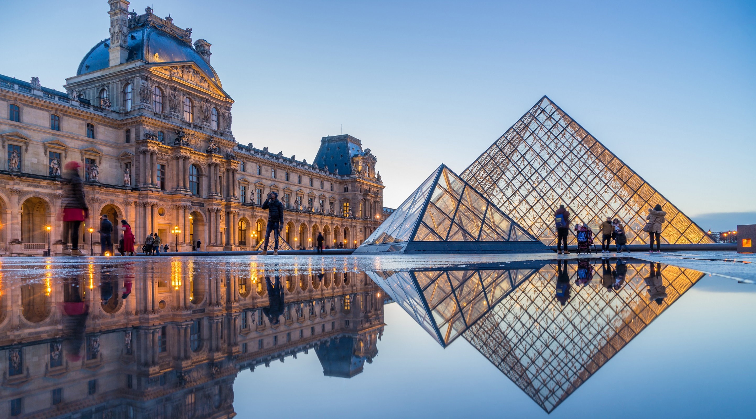 iew of famous Louvre Museum with Louvre Pyramid at evening