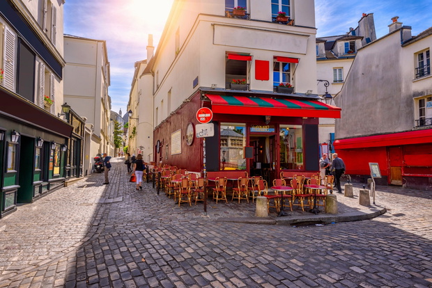 Cozy street with tables of cafe in quarter Montmartre in Paris,