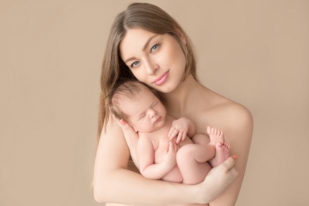 sleeping newborn baby in the mother's arms