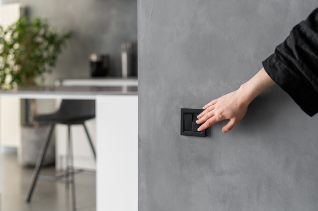 Woman turning light on or off in kitchen