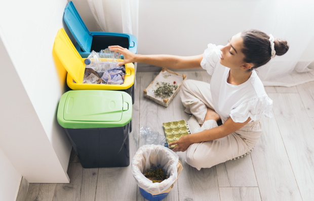 young woman recycling plastic bottle at home
