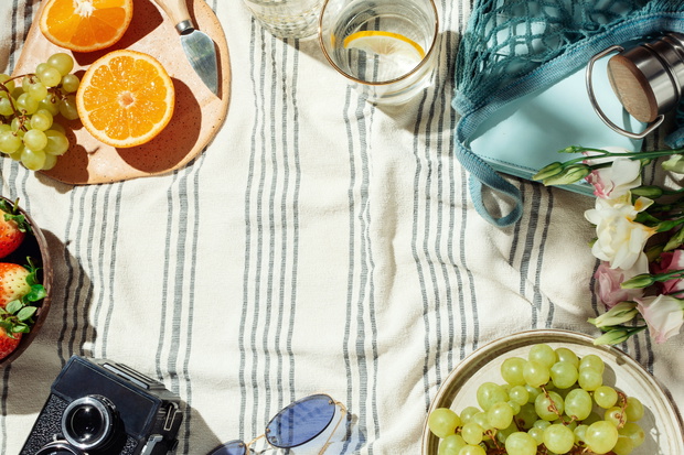 Summer picnic flatlay, fruits, berries and lemon water on stripe