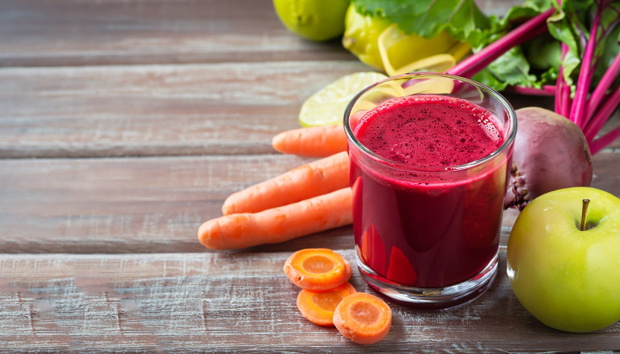 Healthy detox beetroot, carrot, apple and lemon juice smoothie in glass on wooden table, horizontal
