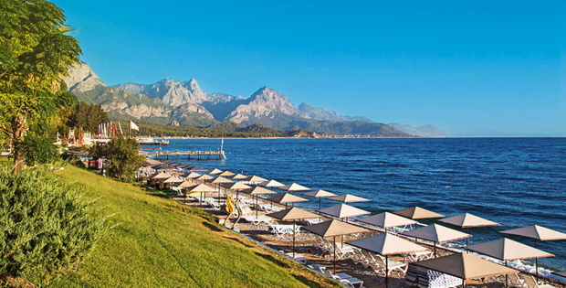 Sunshades and chaise lounges on beach. Turkey, Kemer.
