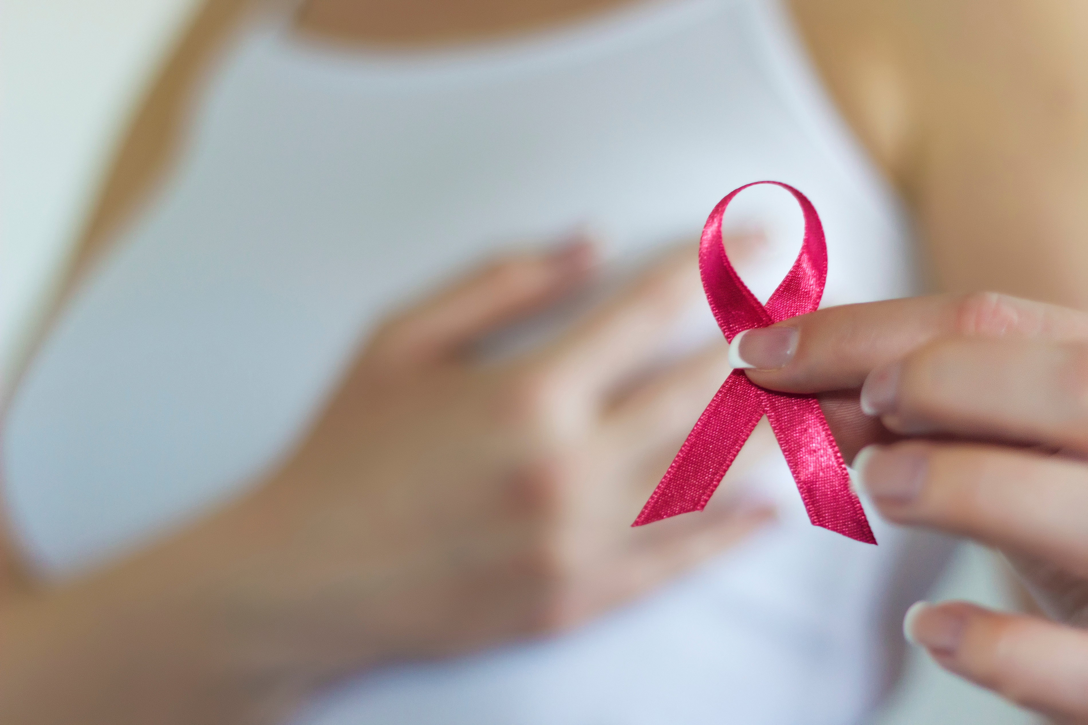 Woman hold pink ribbon for breast cancer awareness