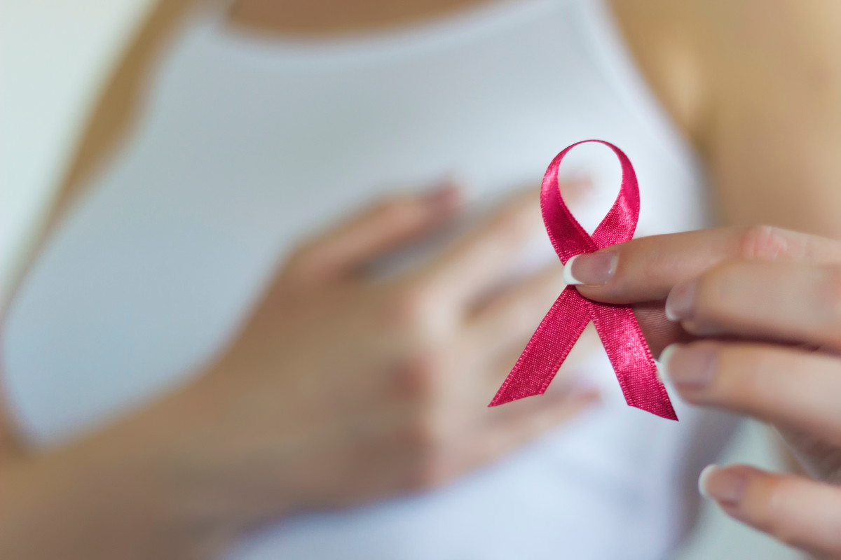 Woman hold pink ribbon for breast cancer awareness