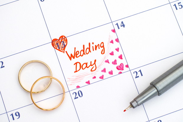 Reminder Wedding day in calendar with pen and two wedding rings