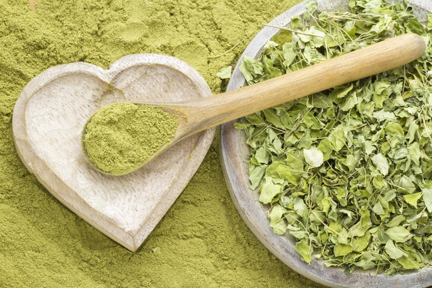 Leaves and moringa powder on wood (long moringa)