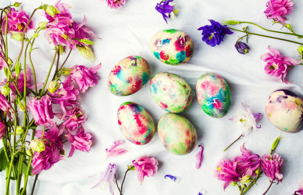 Easter eggs and colorful iris flowers on white textile