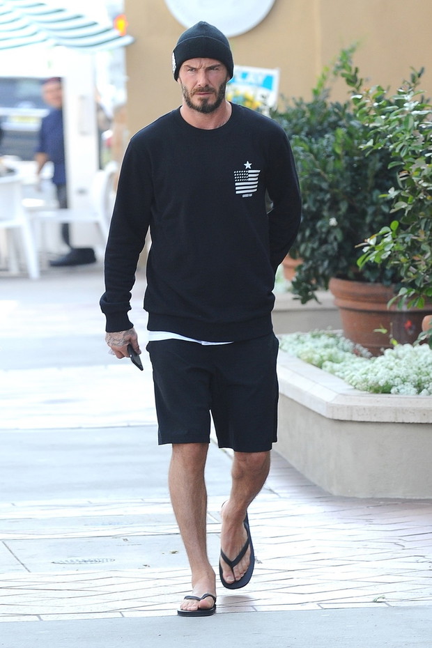 David Beckham w czapce i klapkach