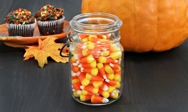 Candy corn in a rustic mason jar.  Pumpkin and cupcakes in the b
