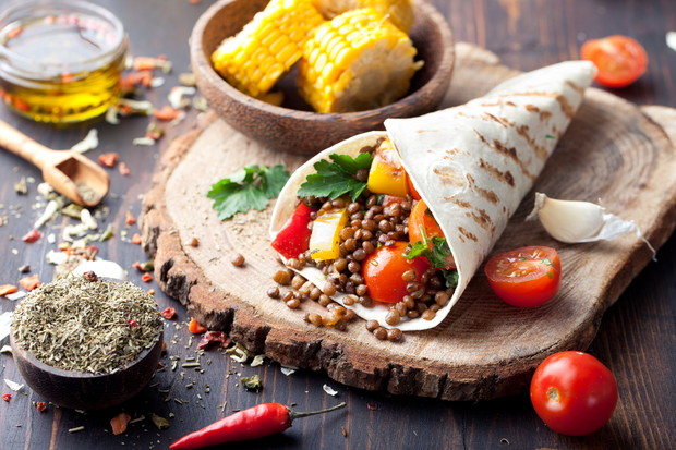 Vegan tortilla wrap, roll with grilled vegetabes, lentil, corn cob.