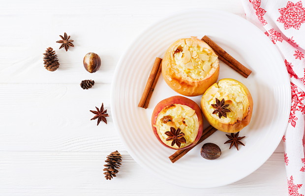 Stuffed baked apples with cottage cheese, raisins and almonds for Christmas on a white background. Xmas food dessert. Top view. Flat lay