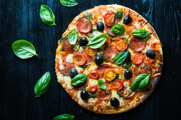 Pizza with salami, olives and basil