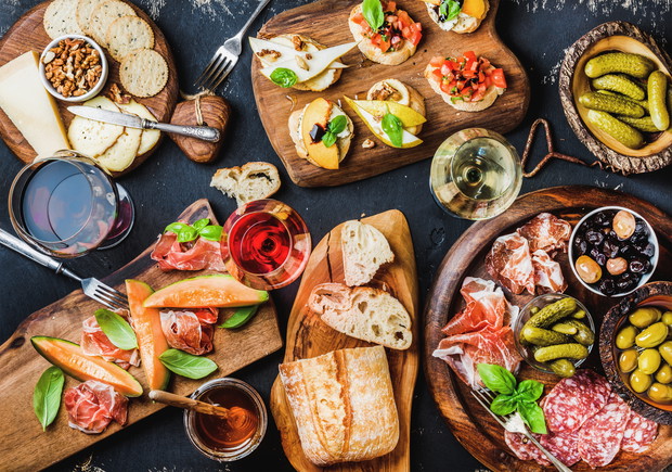 Italian antipasti wine snacks set over black grunge background