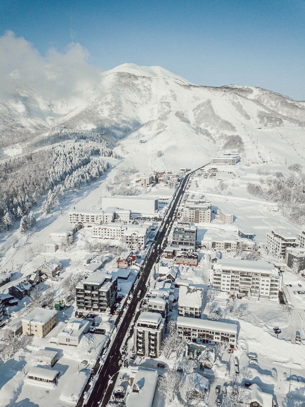 Winter in Niseko, Japan. A blue bird kind of day at Grand Hirafu, Niseko Ski Resort. Photos were taken with a drone overlooking the Grand Hirafu area with views of Mt. Niseko-Annupuri. and Mt. Yotei.