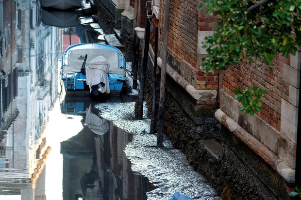 A boat is seen in a canal during an exceptional low tide in the lagoon city of Venice