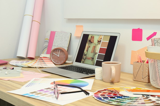 Designer's workplace with modern laptop and color palettes