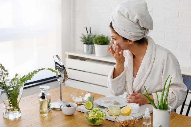 Young woman applying face mask at home. Natural Skin Care Routine. Cleaning face with natural cosmetics.