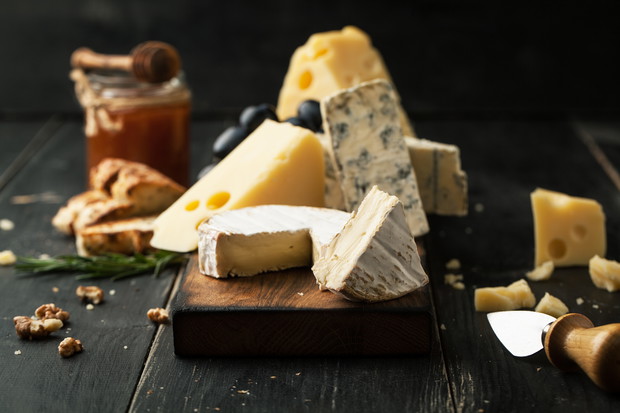Assorted cheeses with grapes, nuts and rosemary