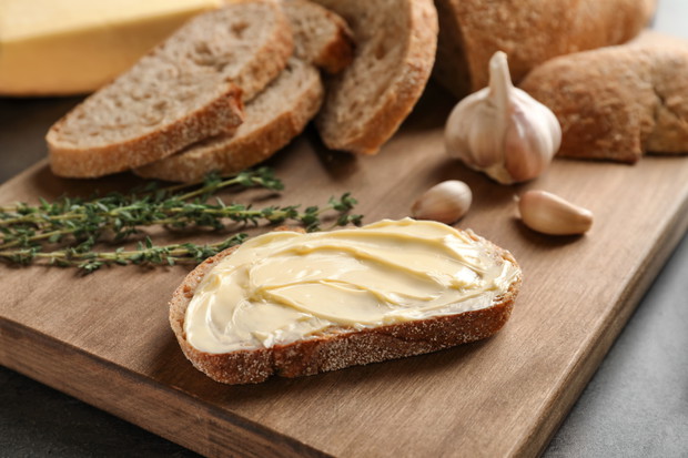 Slice of bread with butter on wooden board