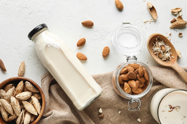 Tasty almond milk on white background