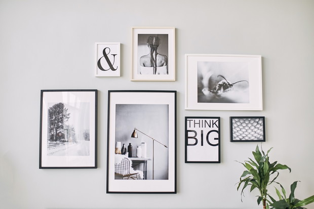 different size framed photos hanging on the gray wall.