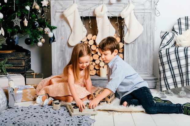 Children playing in new year interior room. Crhistmas tree with