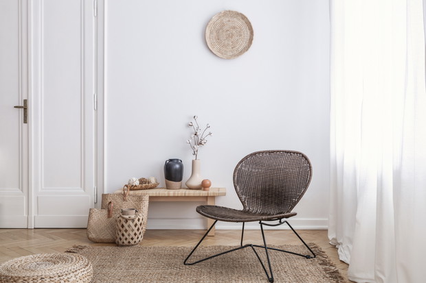 Modern armchair and pouf on brown carpet in white apartment inte