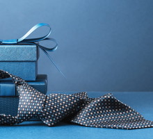 Happy Fathers Day background. gift box and necktie on blue table.